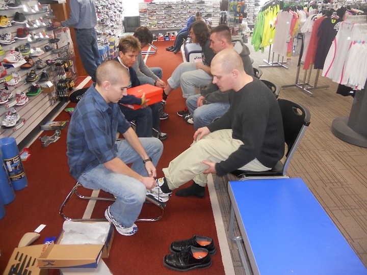 Sponsored runners from Guiding Light in the Fifth-Third River Bank 10K get fitted for shoes.