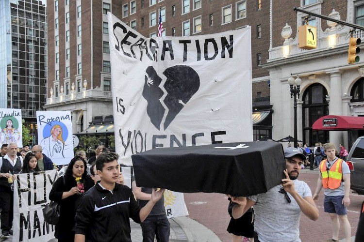 Marchers carry a symbolic coffin, mouring those who've been killed by ICE agents.