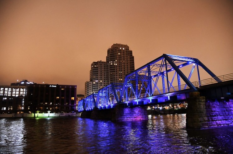The Blue Bridge, the Grand River, and the buildings of downtown Grand Rapids lit up at night