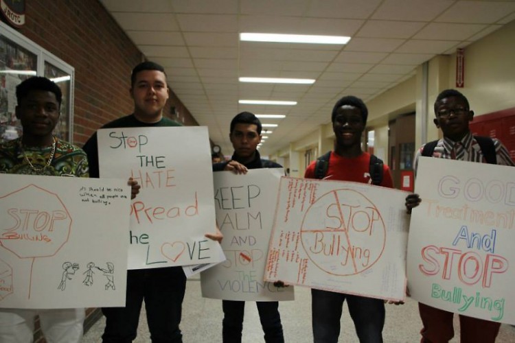 Students hold signs during a silent demonstration, urging their peers to take action against bullying. 