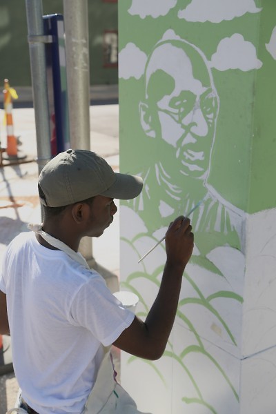 Chris Harris, 16, works on a mural of Ghandi at Fulton and LaGrave