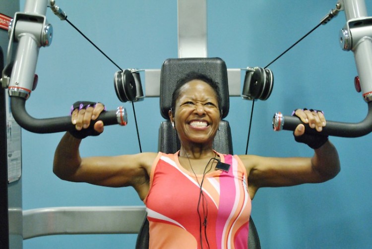 Leah Thomas listens to music as she uses the chest press machine in the Kroc Center. She lifts 40 pounds. 