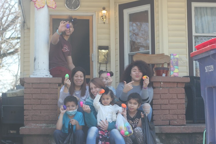 A family shows off the eggs they received for the Community Kids "home delivery" egg hunt.