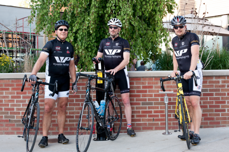 Team Speed Merchants Bike Shop of Rockford pose in front of the newly installed bicycle repair stand at Brewery Vivant