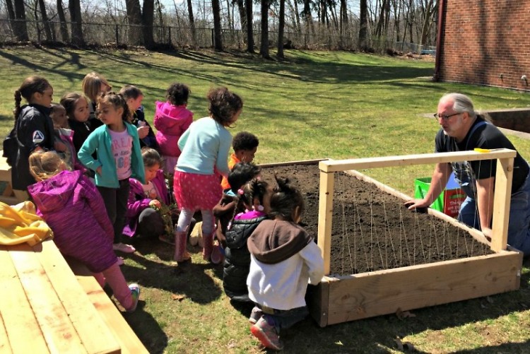Preschoolers work with Jeff Smith from Gardens for Grand Rapids to build their garden.