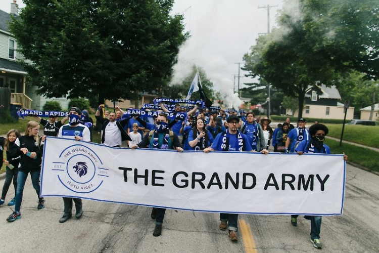 Grand Army members march from Bob's Sports Bar to Houseman Field prior to a Grand Rapids Football Club match last season.