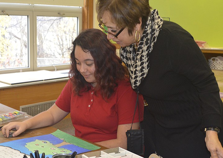 Southwest Community Campus Principal Carmen Fernandez talks to eighth-grader Angelica Morazan about her artwork