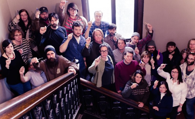 Community Media Center staff raise their pens to freedom of expression, speech and the press