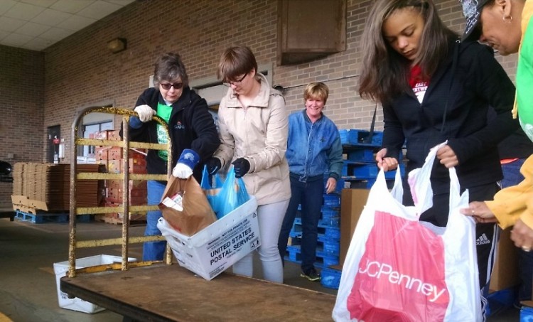 Staff and volunteers from Feeding America West Michigan unload food at the Kentwood Post Office branch.
