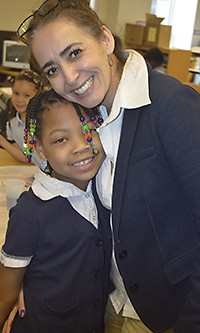 Harrison Park second-grader La’Rae Murray gets a warm hug from LOOP program supervisor Irma Alicia Lopez 
