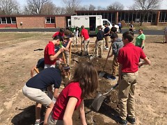 Students at All Saints Academy get a lesson in digging beds