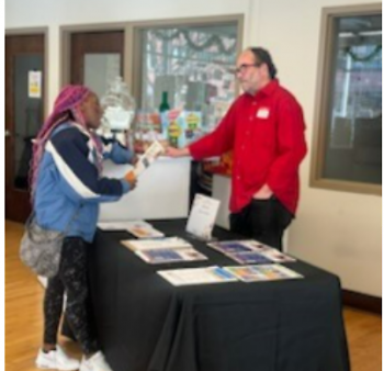Dwelling Place resident receives information about Dwelling Place's CLT affordable home ownership program