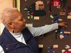Paulette Moncure points to areas in her Quilt Story featuring rural Mississippi to Grand Rapids