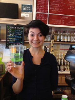 Amanda Ebenhoeh of The Sparrows Coffee Tea & Newsstand displaying their compostable cups.