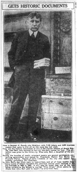 Samuel Ranck, first director of the Grand Rapids Public Library, holds a box of letters written by early pioneer John Ball