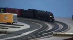 Locomotive model train rolling down the tracks.