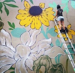 Artist Louise 'Ouizi' Chen painting the new mural on the Grand Rapids Ballet Company's building.