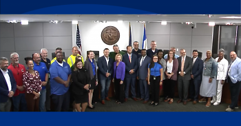 City officials and water system workers posing for a photo in the City Commission chambers at City Hall