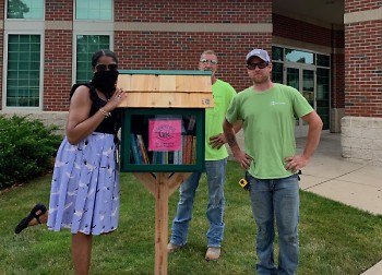 Zandra Blake, GRPL Seymour Branch Manager, and Rockford Construction crew admiring new Storytime Grand Rapids Book Pantry.